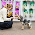 Elisabetta Pierangelo, vice-presidente global de P&D da Mars Pet Nutrition, distribui PEDIGREE Dentastix Light para cães no escritório pet friendly da Mars.