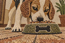 Beagle dog mosaic art eating from a green bowl with bone design, made from colorful beads and stones