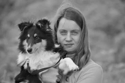 Young girl holding a black and white Rough Collie dog outdoors in black and white portrait photography